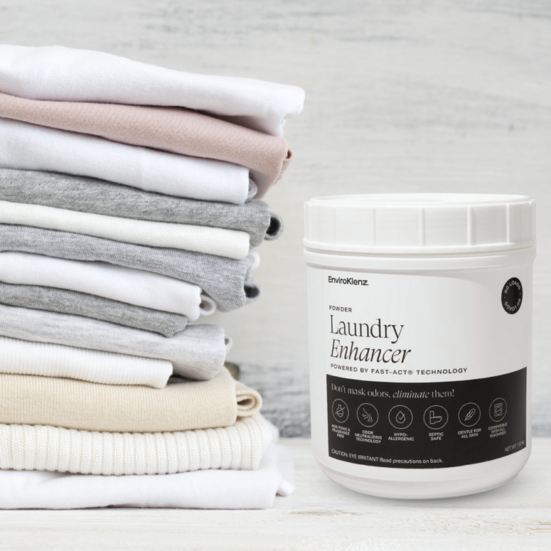 EnviroKlenz Laundry Enhancer Powder Next to a Stack of Clothes