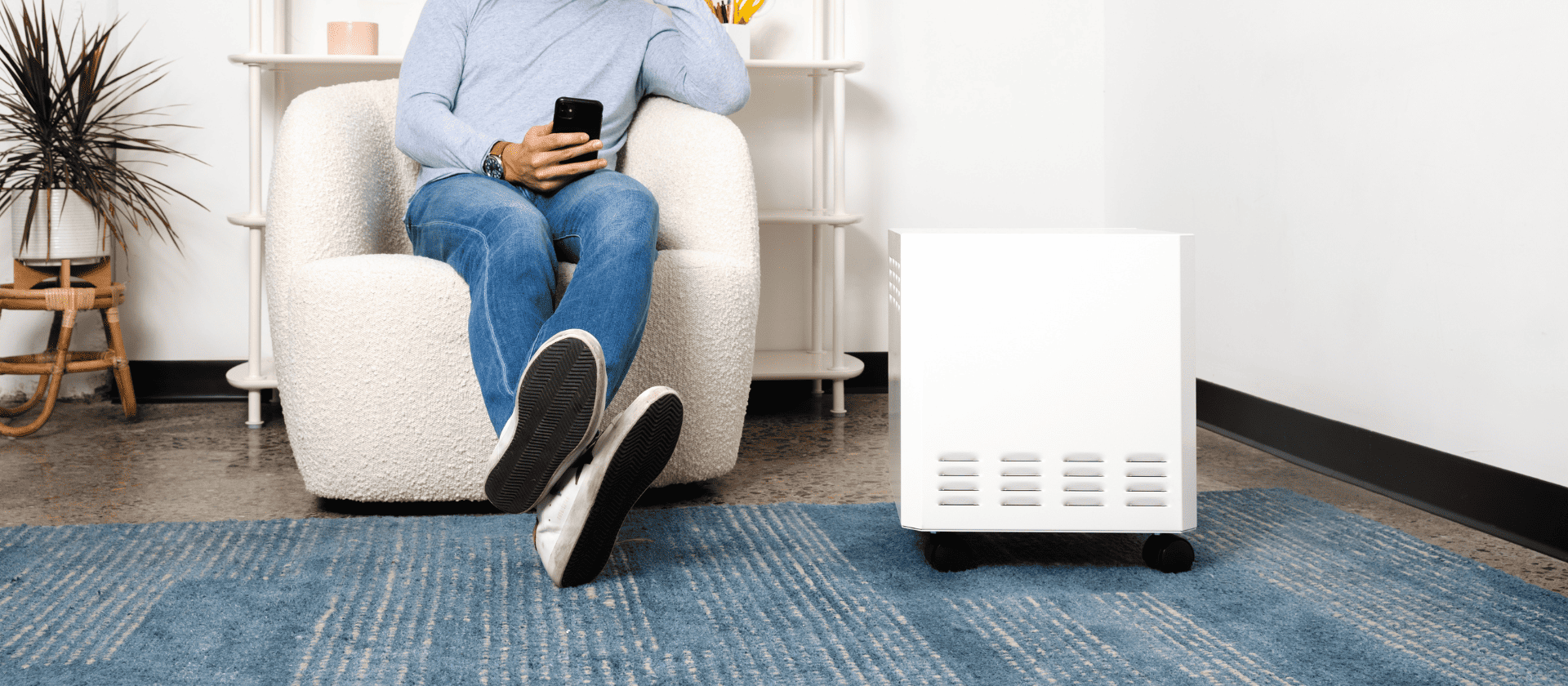 Person, holding phone, sitting next to the EnviroKlenz Air System